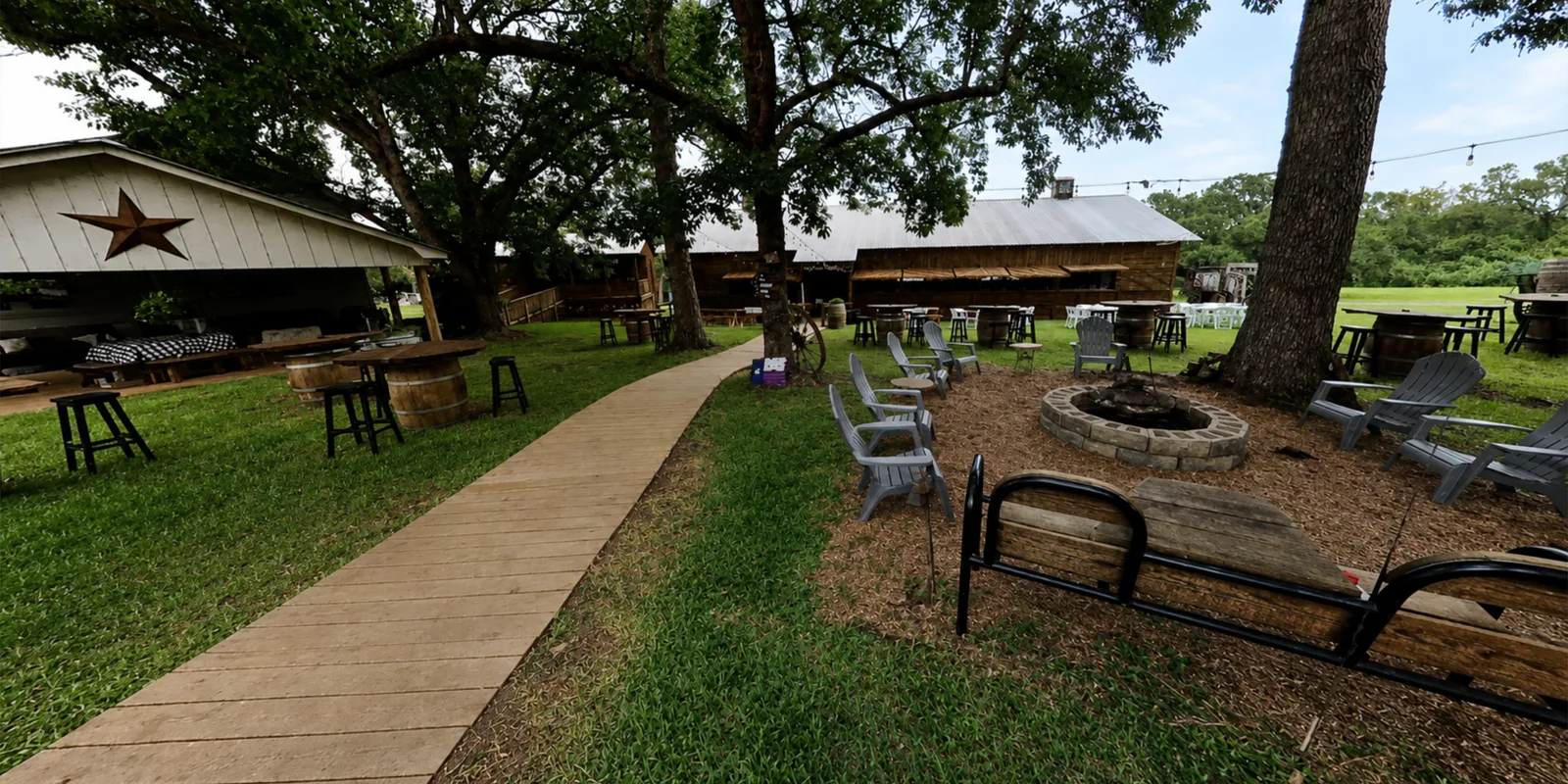 The firepit lawn with adirondack chairs and barrel tables